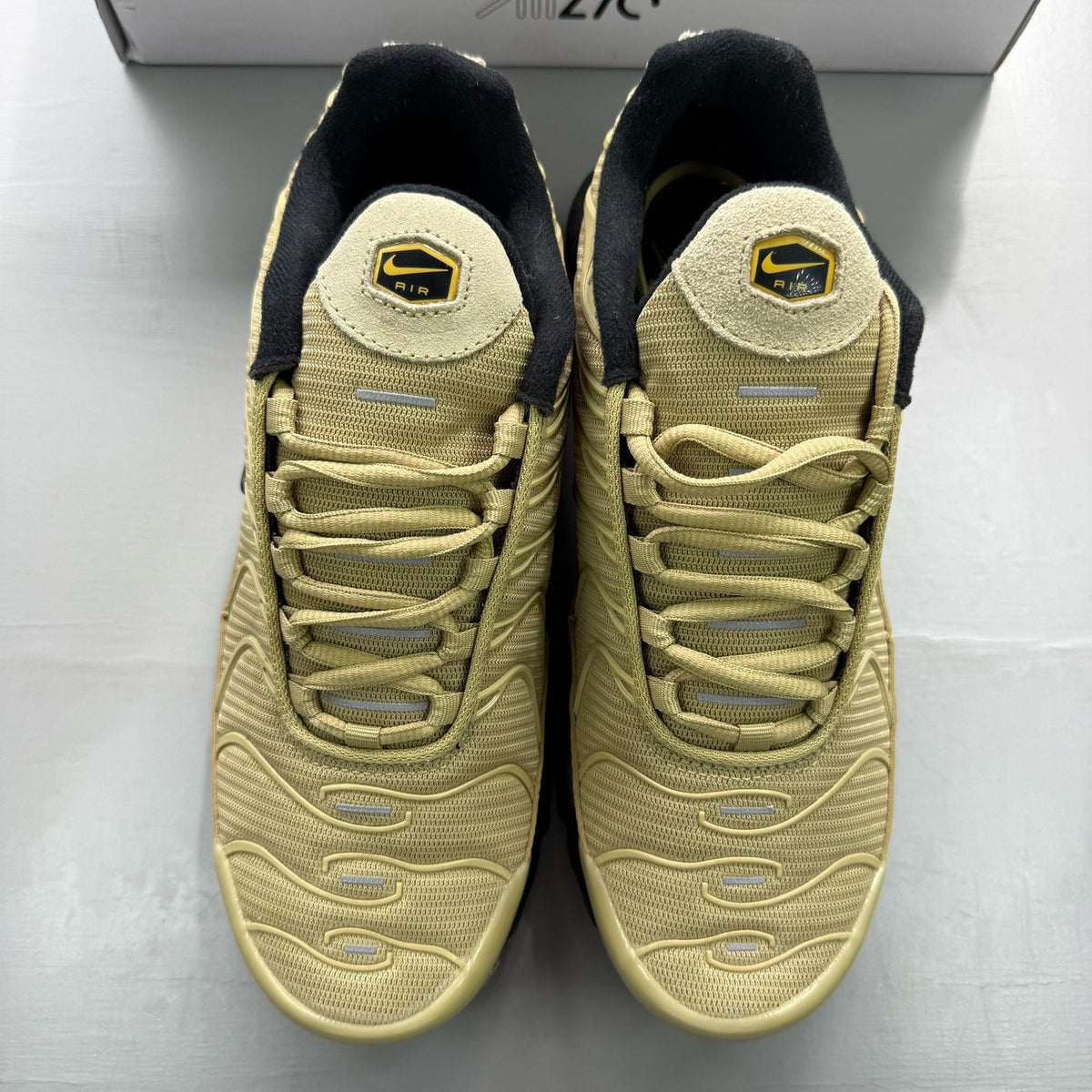 Nike Air Max Plus TN beige trainers with iconic logo and textured upper design.