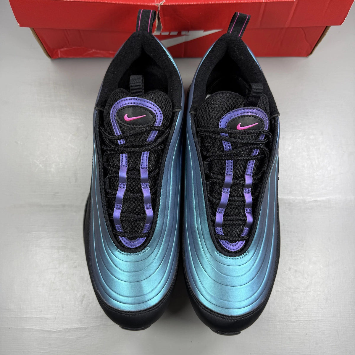 Nike black Air Max 97 trainers with blue accents and reflective detailing.