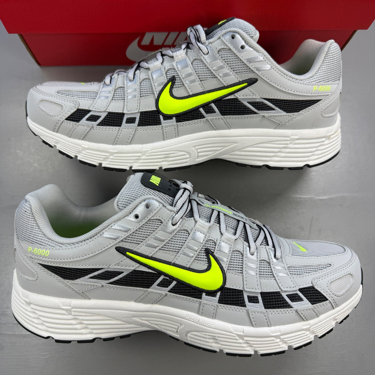 Nike athletic shoes grey with black and volt accents, mesh upper and logo detail.