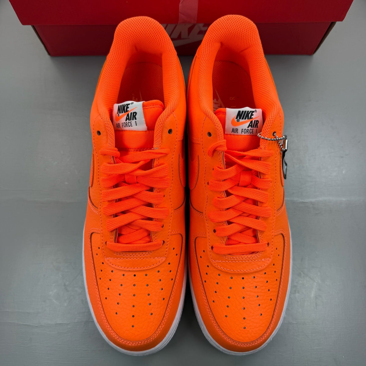 Nike Air Force 1 Low orange trainers with 'Just Do It' logo and sleek design.