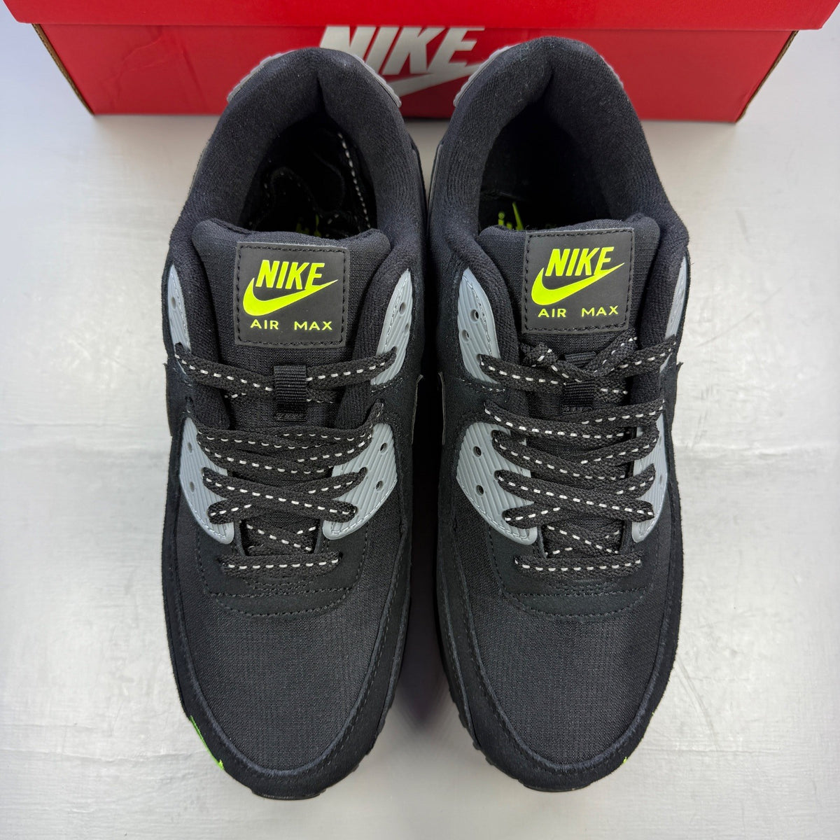 Nike Air Max 90 black with volt accents and mini swoosh logo, brand new condition.