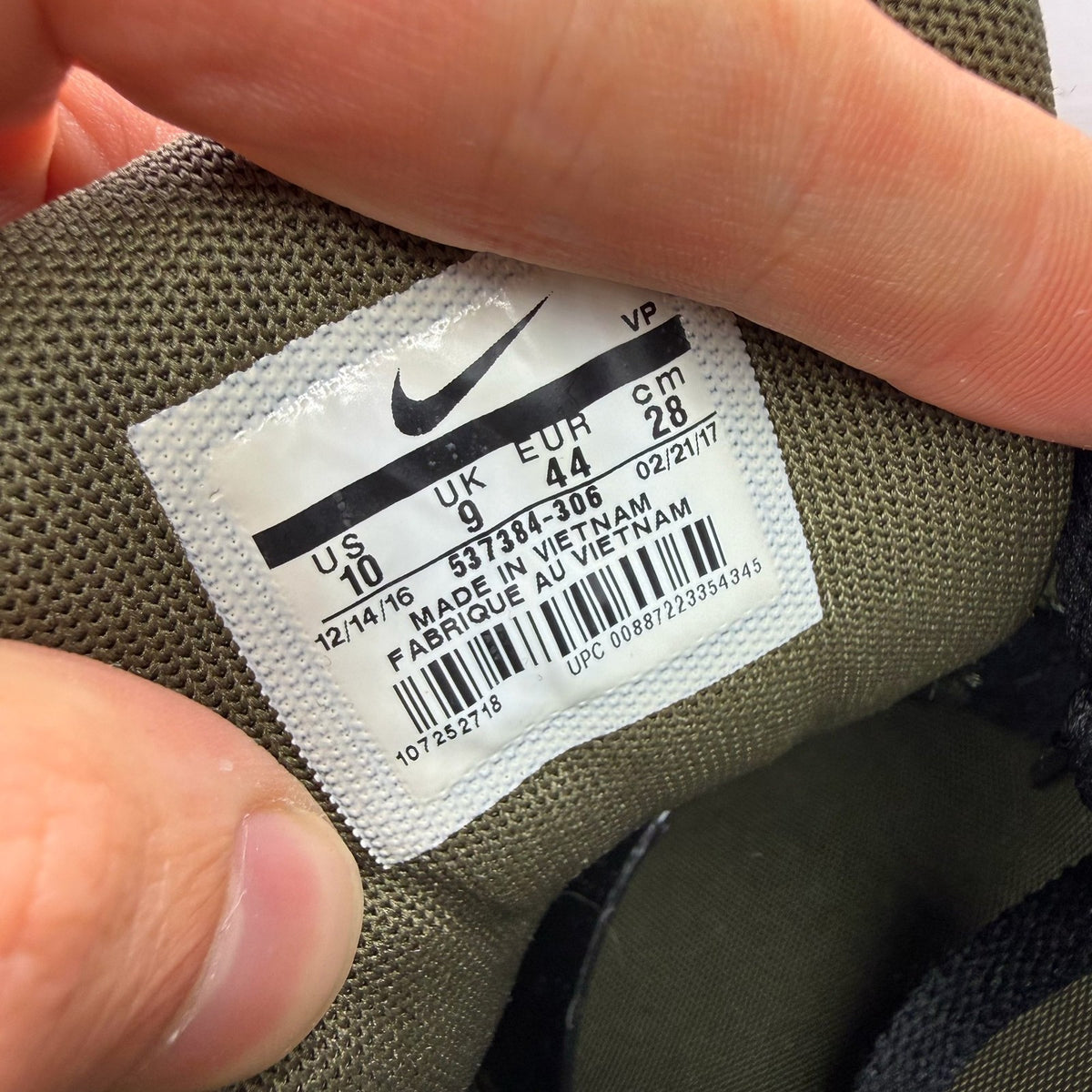 Nike Air Max 90 green trainers with black accents and logo detail.