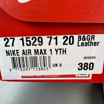 Nike Air Max 1 black trainers with silver and white accents, featuring iconic logo.