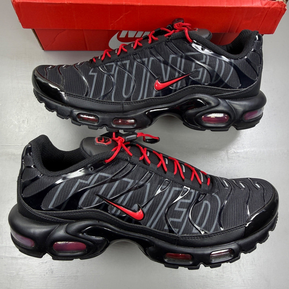 Nike Air Max Plus TN black trainers with red accents and iconic Tuned Air sole.