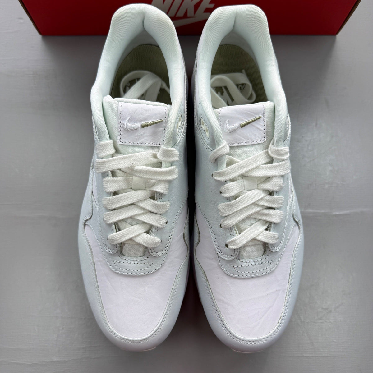 Nike Air Max 1 white trainers with rubberized details and classic logo design.