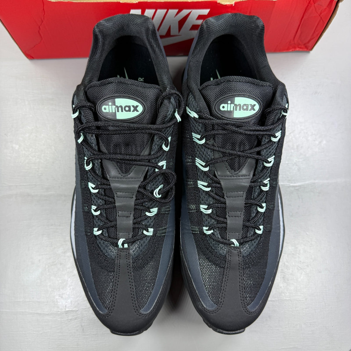 Nike running shoes black with mint foam accents and anthracite detailing.