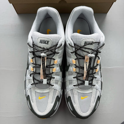 Nike grey P-6000 trainers with laser orange accents and mesh material.