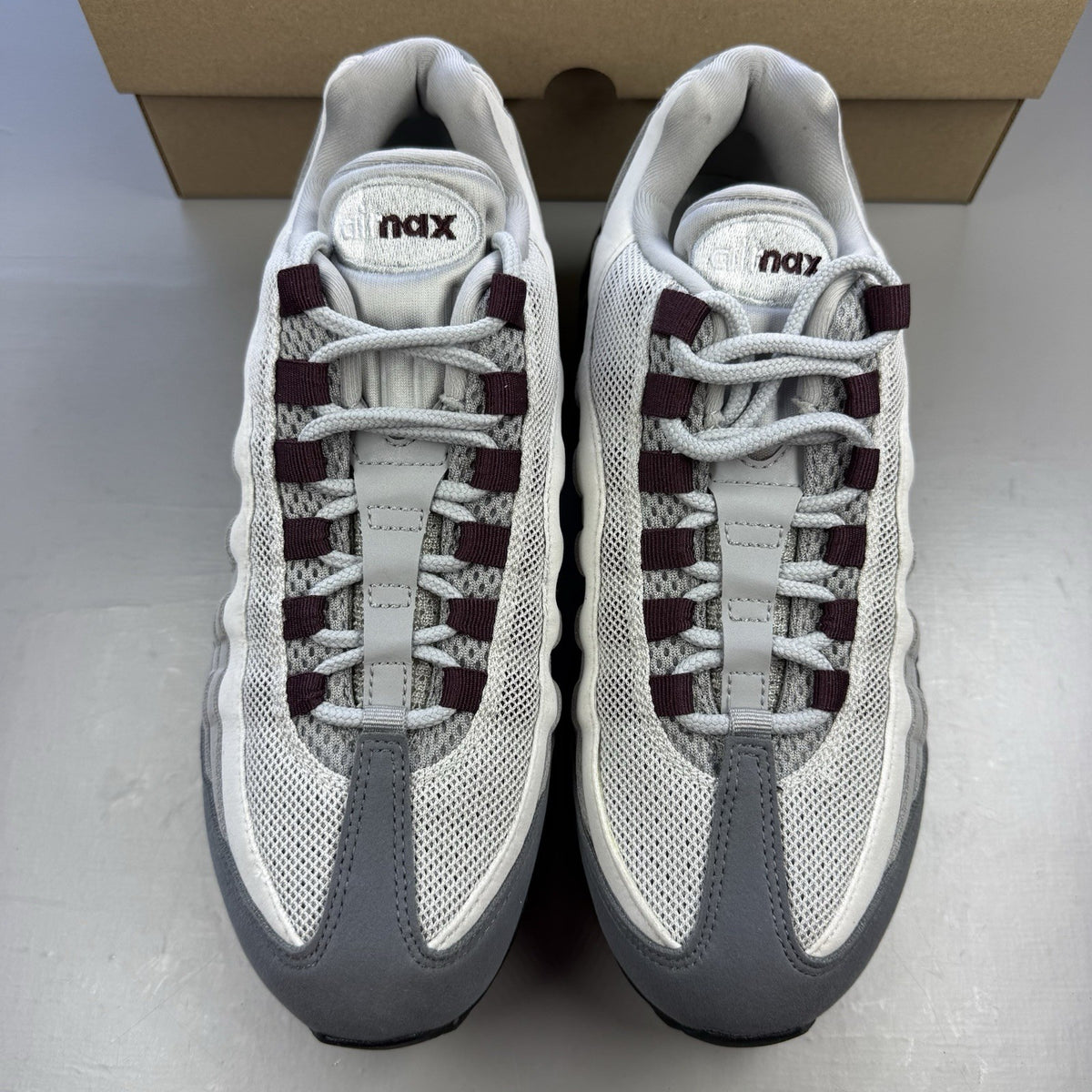 Nike Air Max 95 OG Big Bubble grey sneakers with burgundy accents and visible air cushioning.