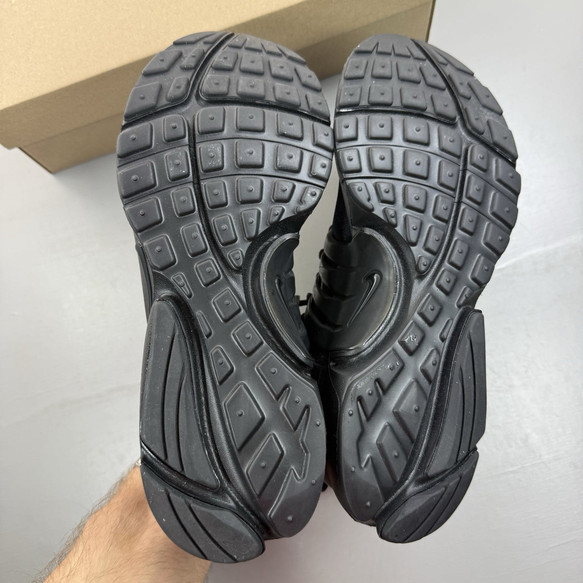 Nike Air Presto black trainers with logo detailing and breathable mesh upper.