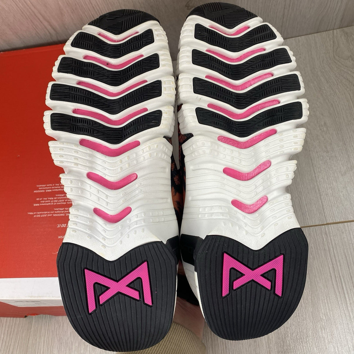 Nike Free Metcon 4 trainers black with tiger burnt sunrise accents and logo detail.
