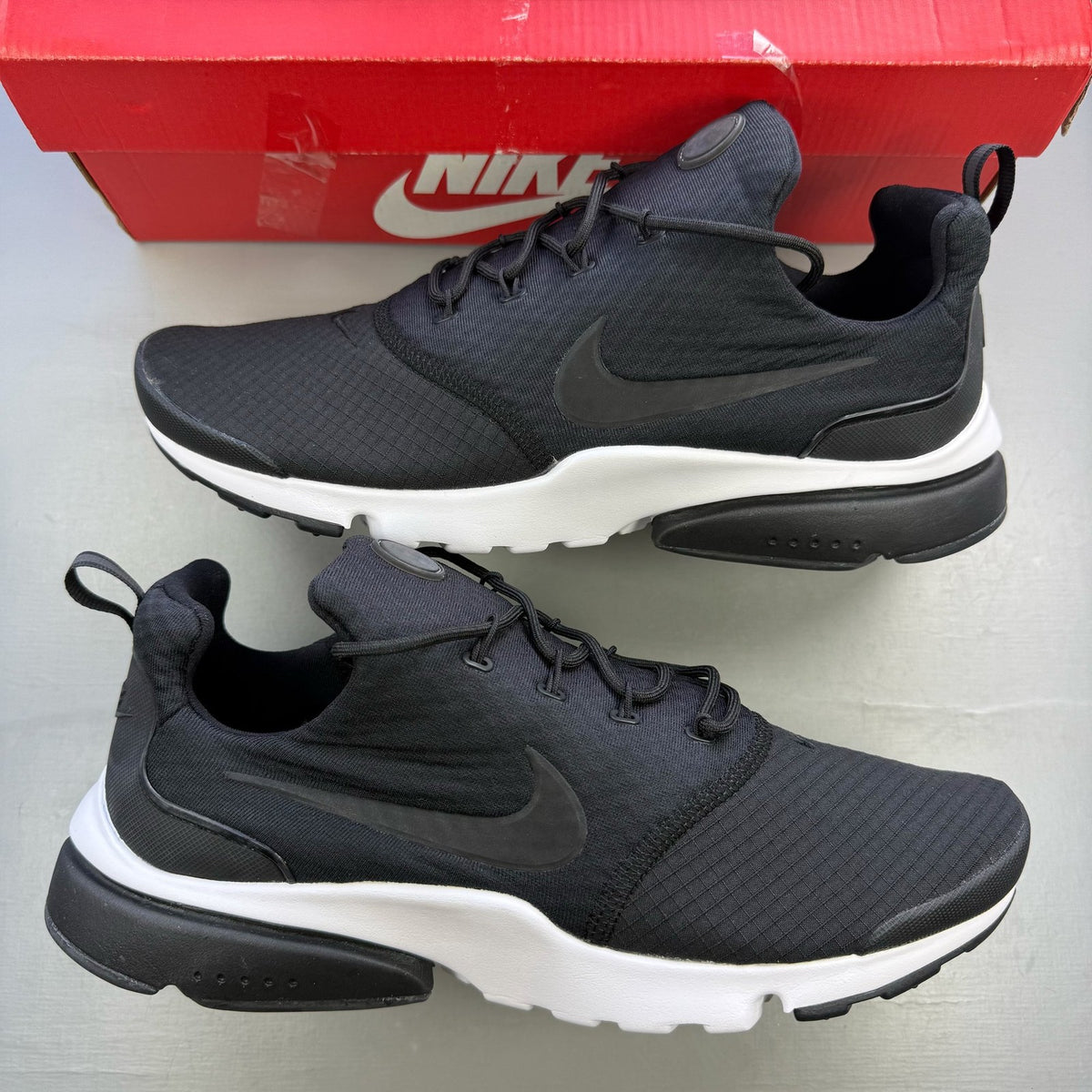 Nike black trainers with white accents and sleek design, featuring logo details.