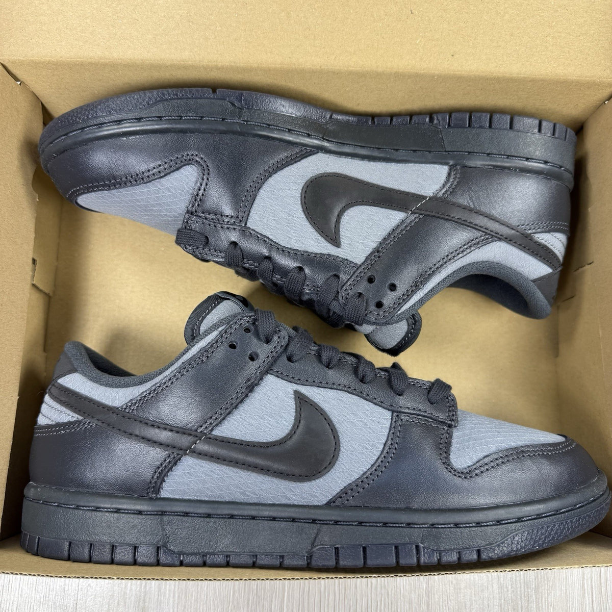 Nike Dunk Low Retro Off Noir grey trainers with black accents and signature swoosh logo.
