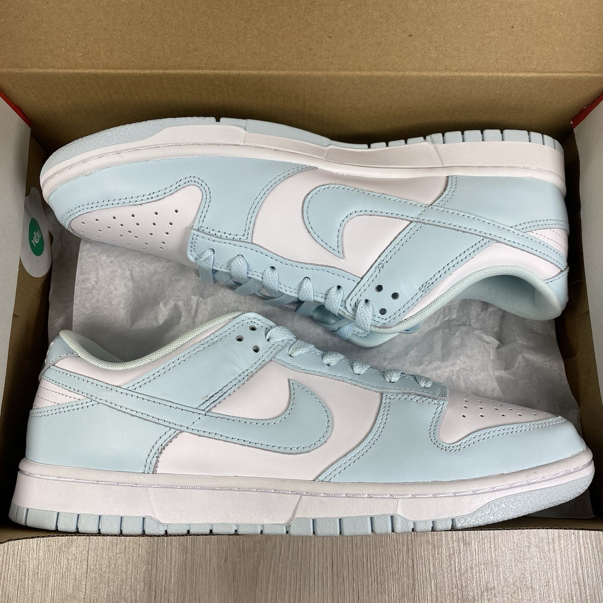Nike Dunk Low Retro trainers glacier blue with white swoosh logo and textured material.