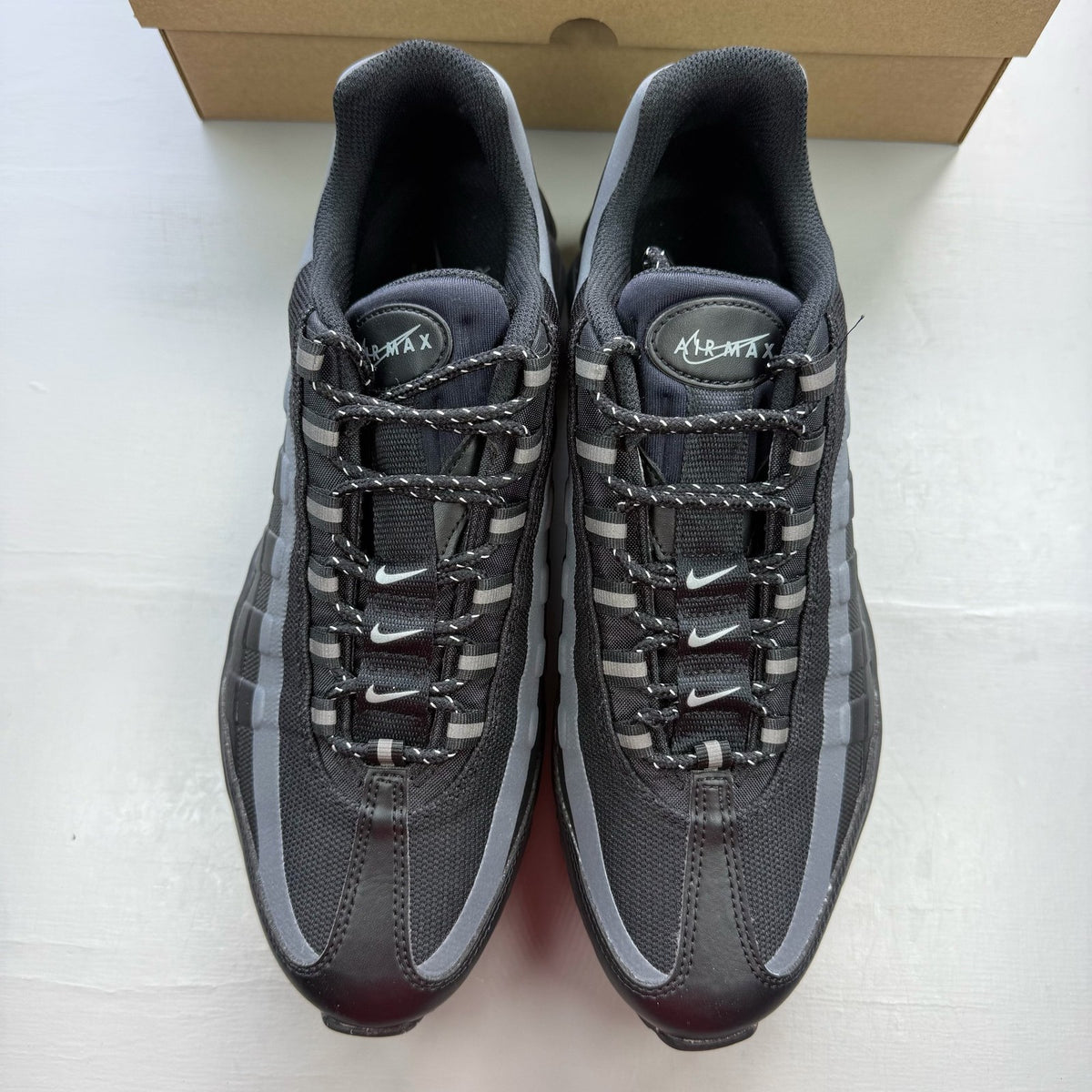Nike black Air Max 95 trainers with reflective details and logo.