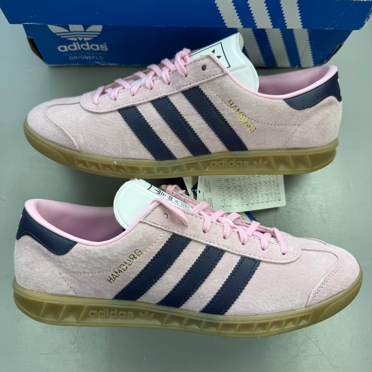 Adidas pink trainers with gum sole, featuring iconic three stripes logo.