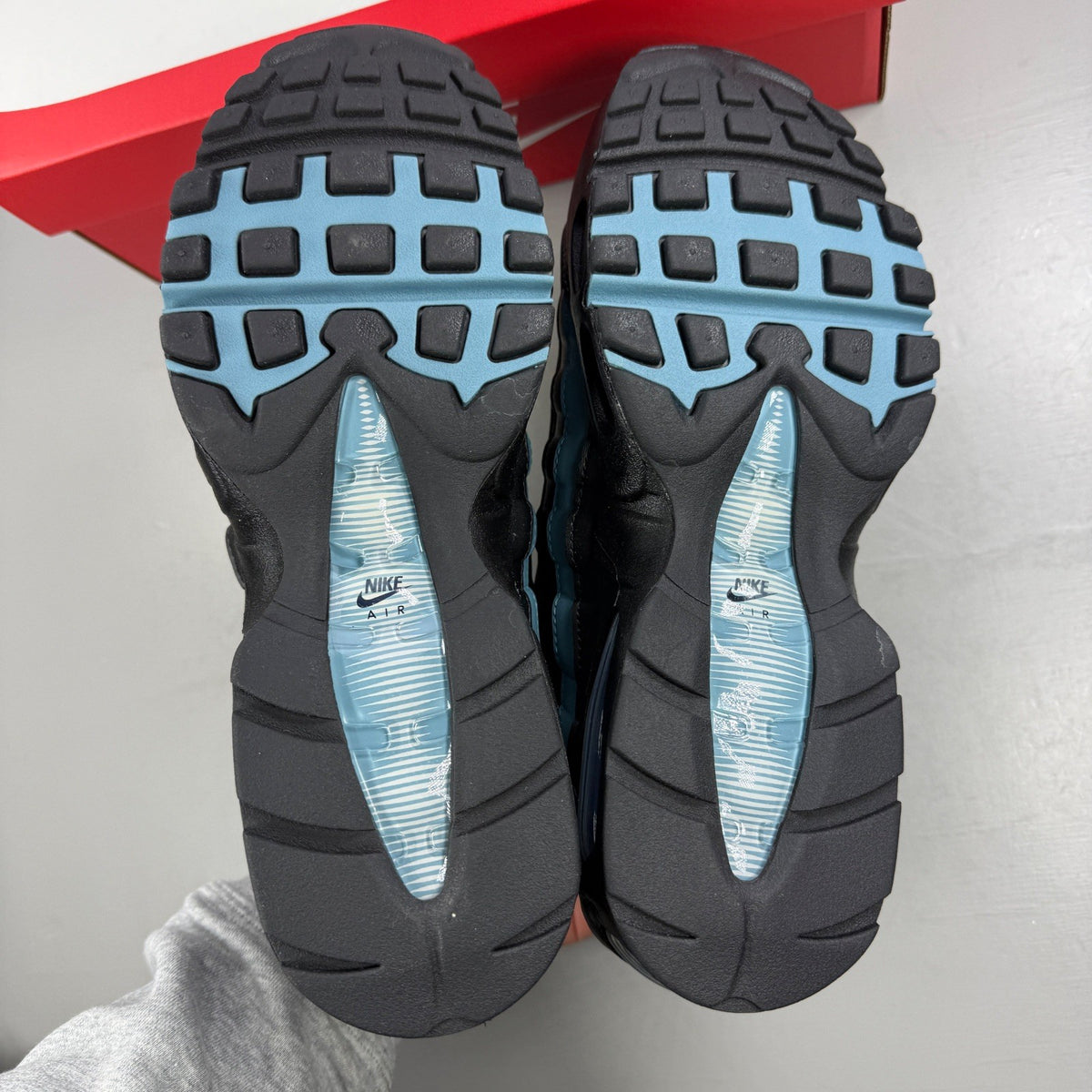 Nike running shoes black with smokey blue accents and visible Air Max cushioning.