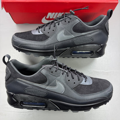 Nike black trainers with grey accents and Air Max cushioning detail.