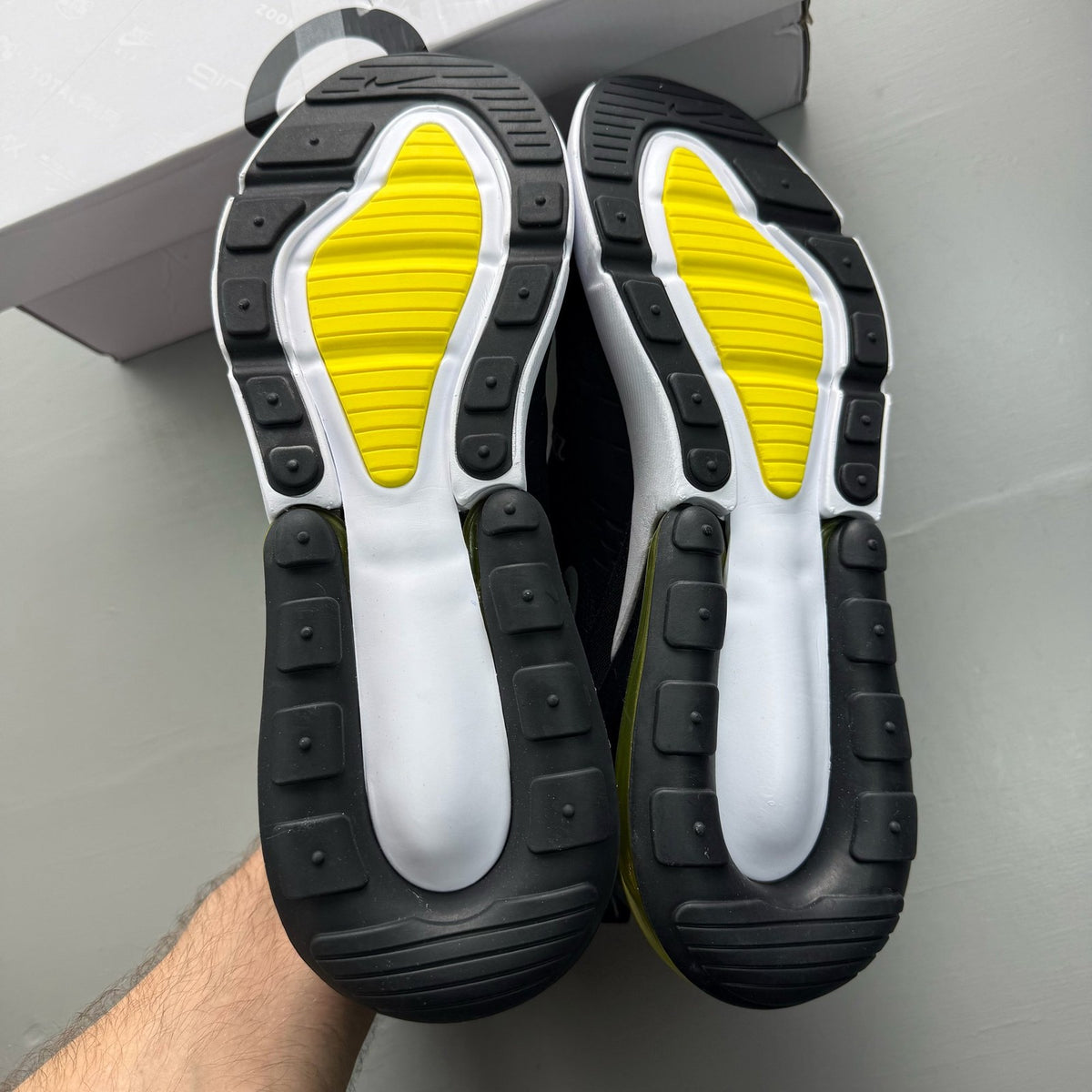 Nike black trainers with Opti Yellow accents and Air Max cushioning.