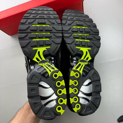 Nike black Air Max Plus TN trainers with chrome accents and vibrant volt detailing.