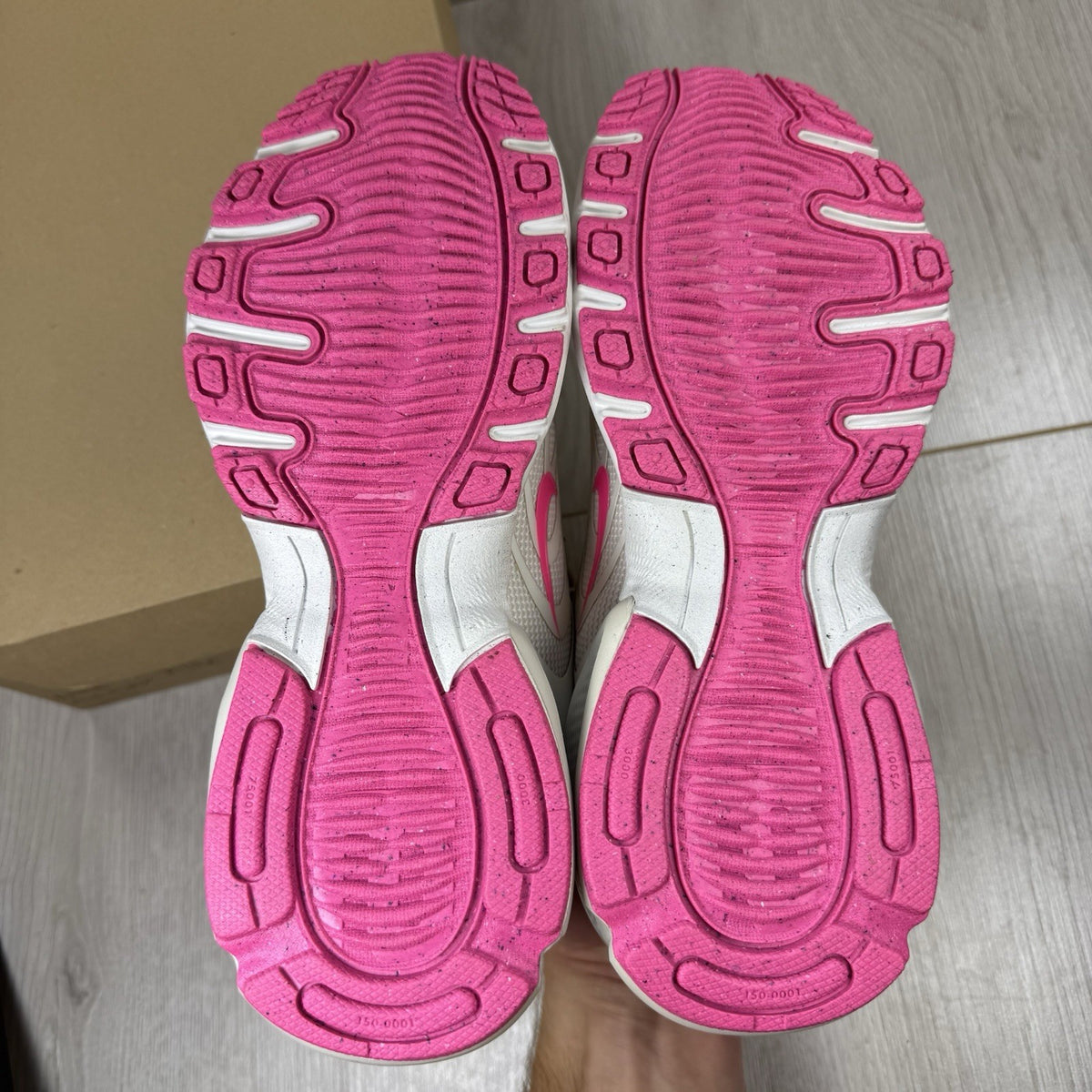 Nike Air Max trainers beige with pink accents and logo detail on the side.
