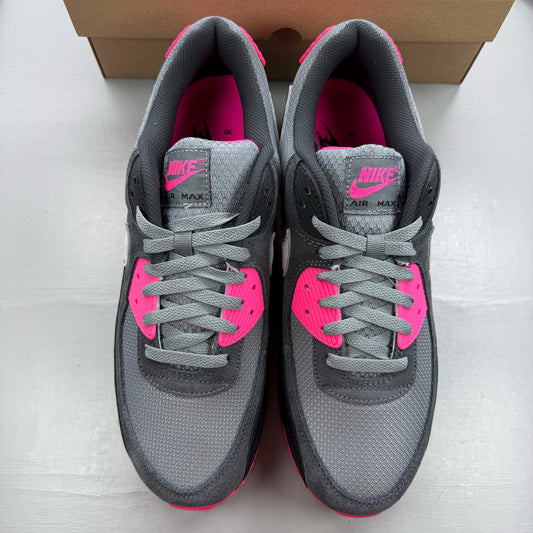 Nike Air Max 90 grey trainers with hyper pink accents and black detailing.
