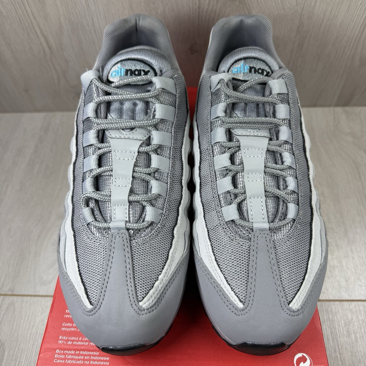 Nike Air Max 95 trainers grey with aqua blue accents and retro logo details.