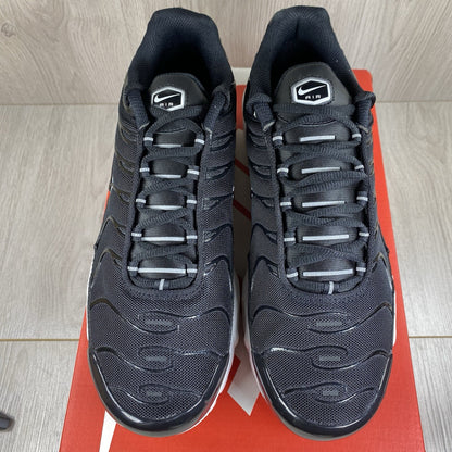 Nike Air Max Plus TN trainers black and white with signature logo and mesh detailing.
