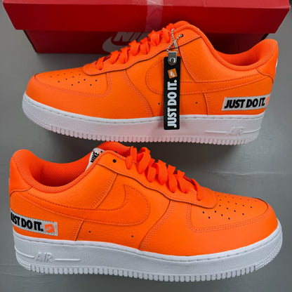 Nike Air Force 1 Low orange trainers with 'Just Do It' logo and sleek design.