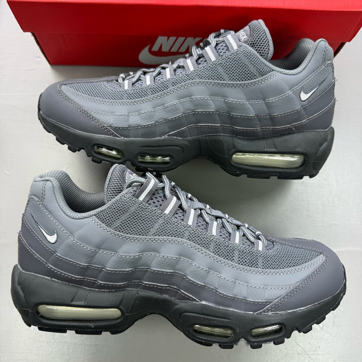 Nike Air Max 95 grey trainers with distinctive design and logo details.