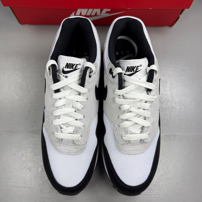 Nike Air Max 1 white trainers with pure platinum and black accents, classic logo detailing.