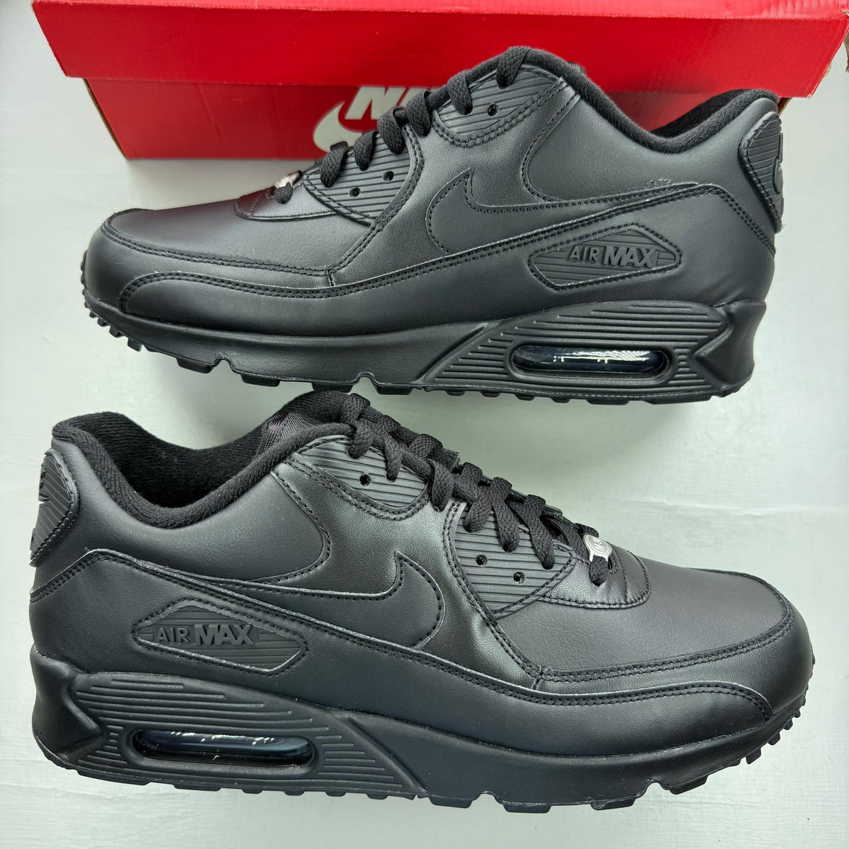 Nike black trainers leather upper with Air Max cushioning and logo detail.