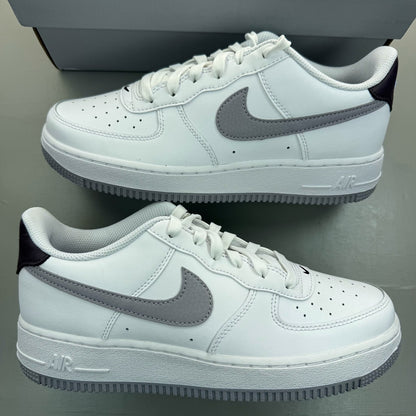 Nike Air Force 1 low white trainers with grey cement accents and logo detailing.
