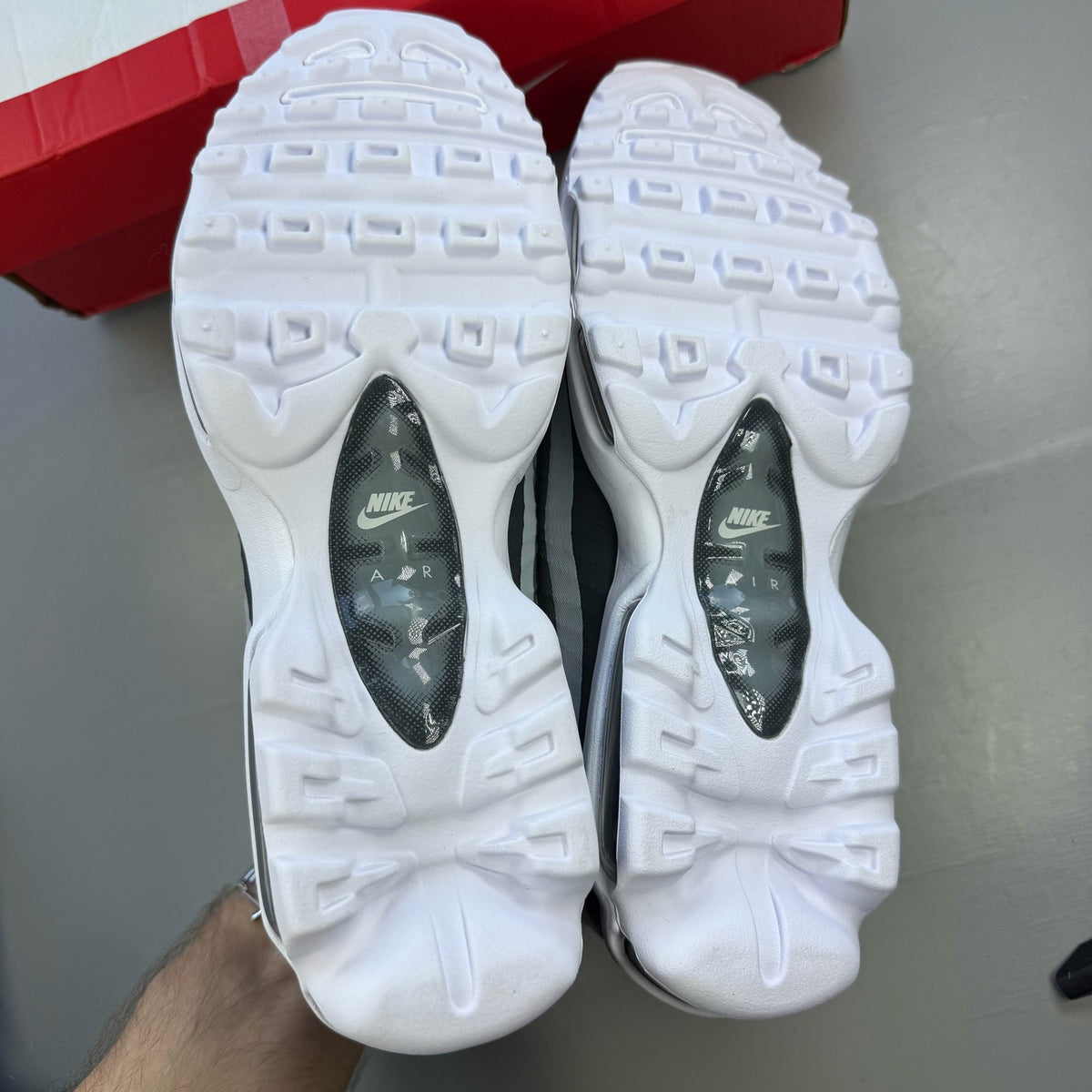 Nike Air Max 95 white trainers with grey accents and signature swoosh logo.
