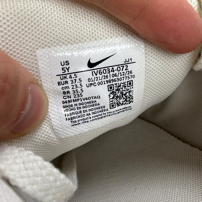 Nike beige athletic shoes with white accents and light bone detailing.