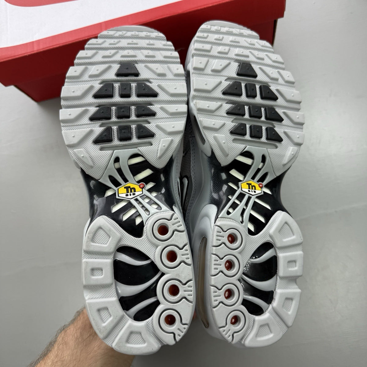 Nike Air Max Plus TN grey trainers mismatched sizes with distinctive logo and sleek design.