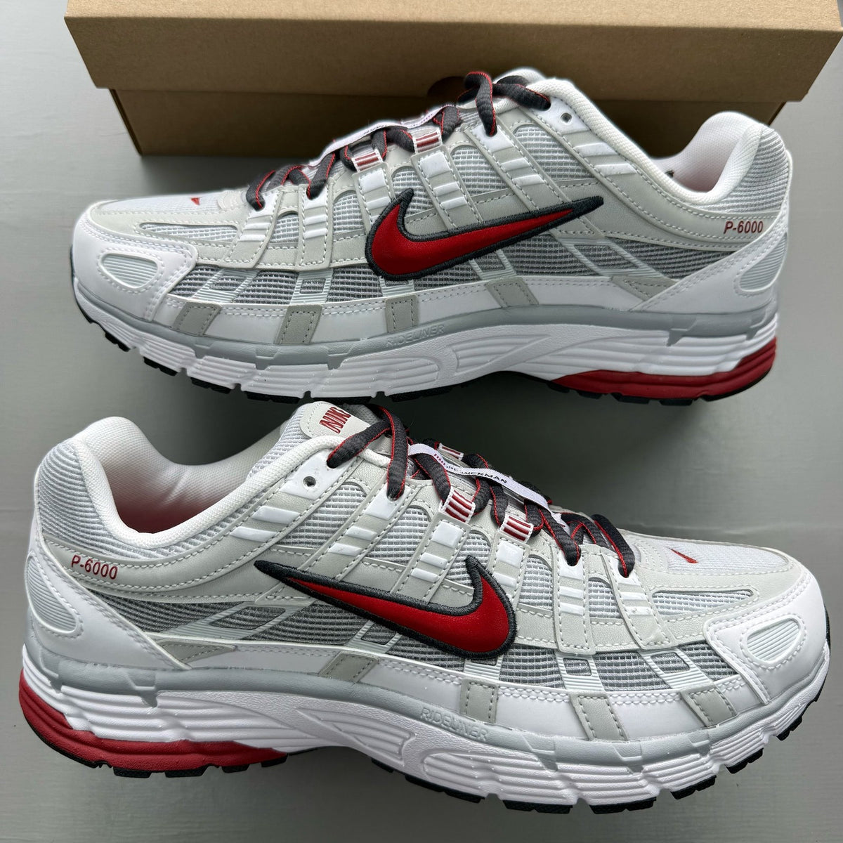 Nike P-6000 white trainers with grey and red accents, featuring a sleek design.