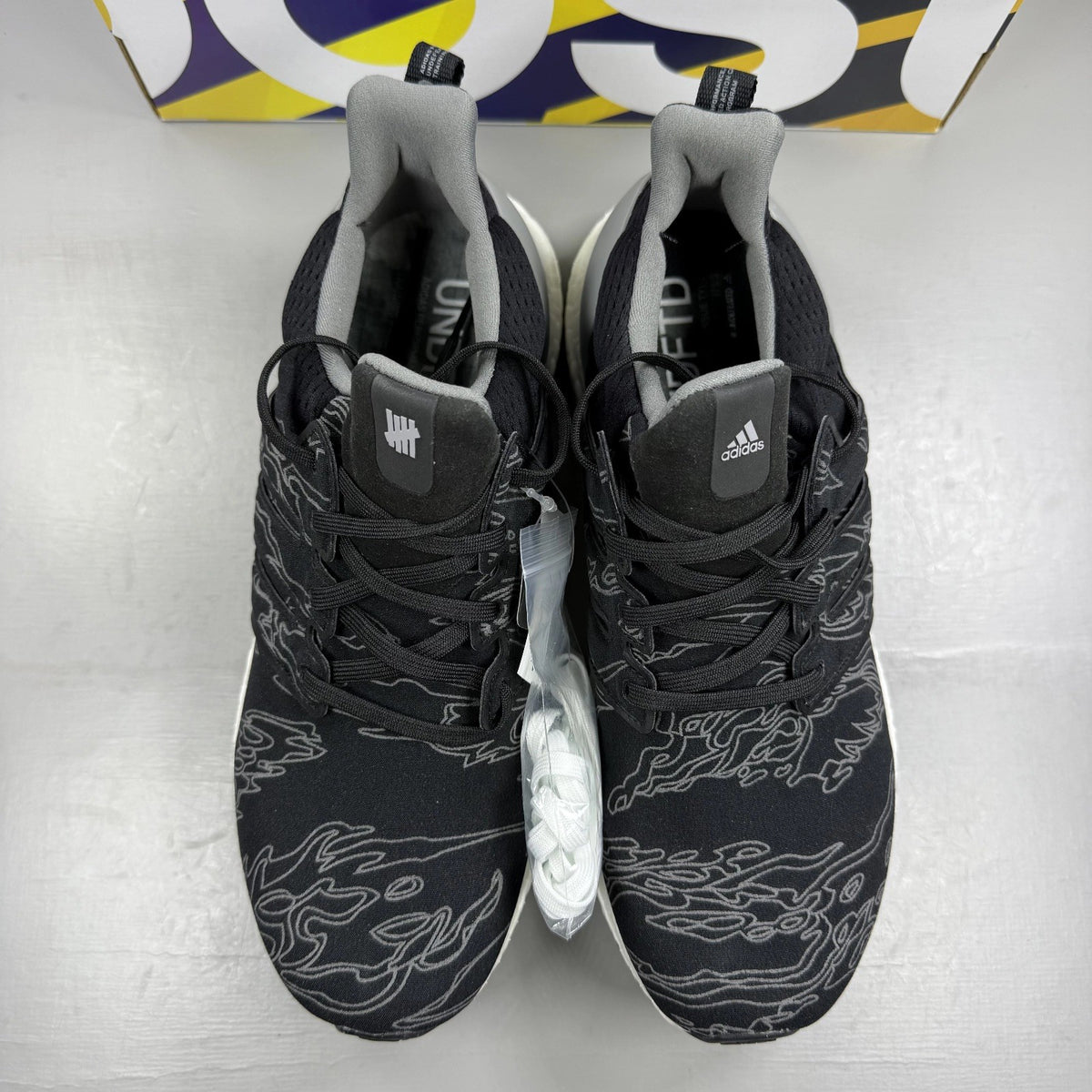 Adidas Ultra Boost black trainers with Undefeated logo and breathable mesh upper.