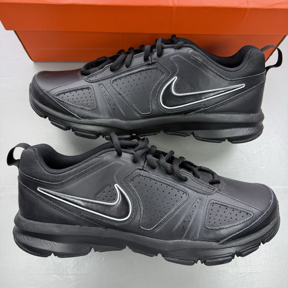 Nike black trainers with metallic silver accents and grey detailing, featuring logo on tongue.