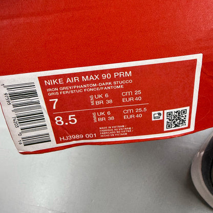 Nike Air Max 90 PRM grey trainers with white accents and distinctive logo details.