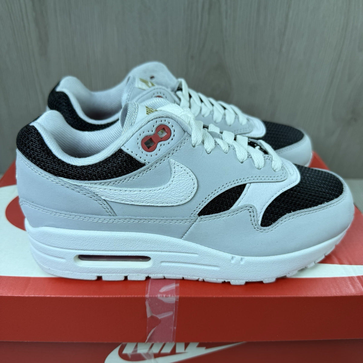 Nike Air Max 1 trainers grey with white accents and signature swoosh logo.