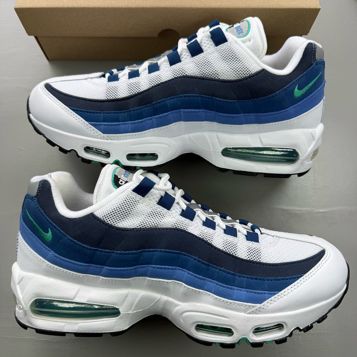 Nike Air Max 95 white trainers with big bubble design and emerald accents.