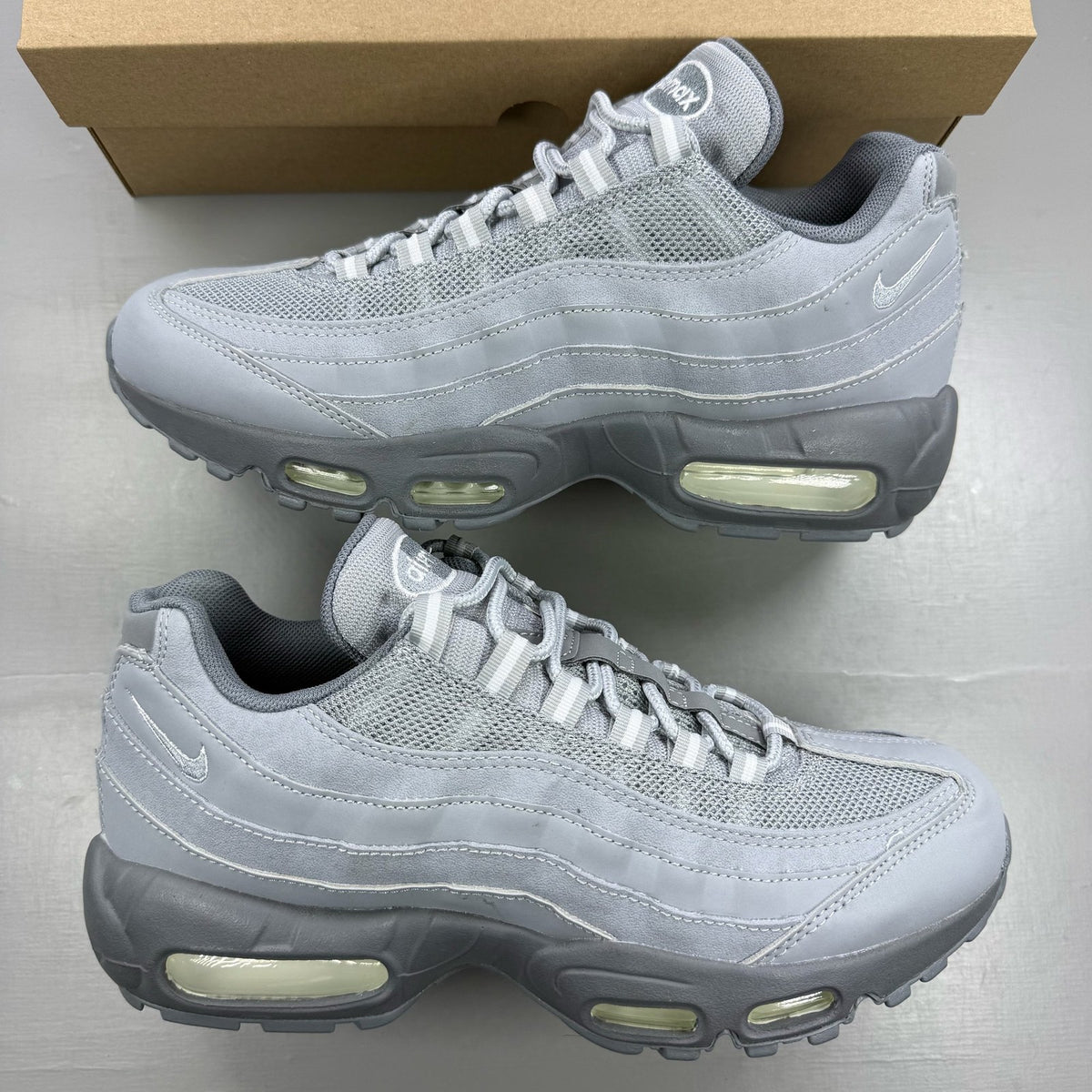Nike Air Max 95 grey trainers with white accents and signature logo details.