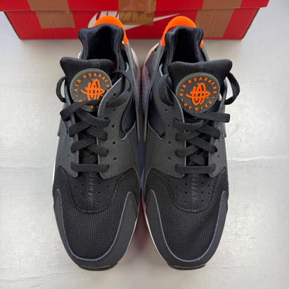 Nike black athletic shoes with safety orange accents and grey detailing.