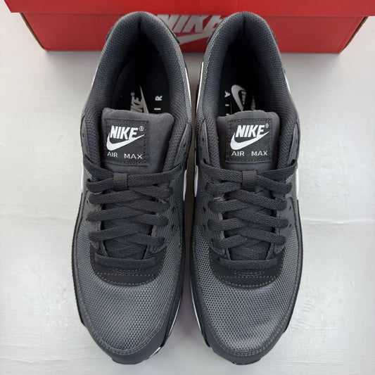 Nike Air Max 90 grey trainers with black and white accents, featuring logo details.