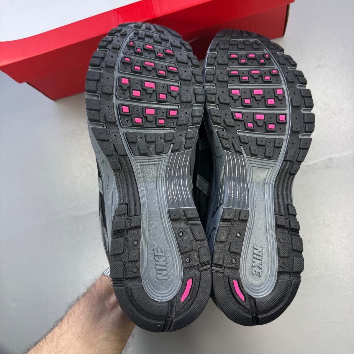 Nike P-6000 grey trainers with pink and black accents, mesh upper and logo detail.