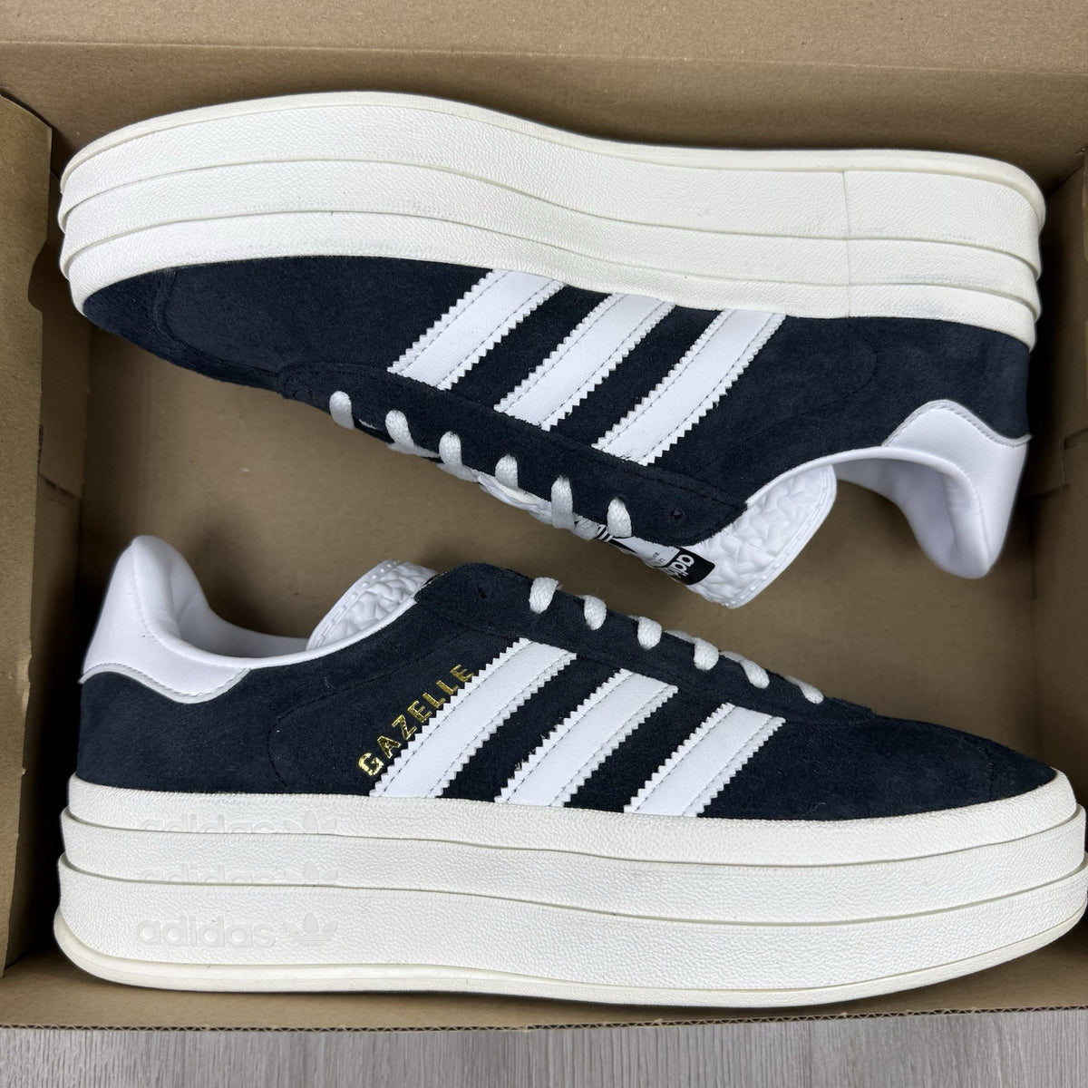 Adidas Gazelle Bold black trainers with white stripes and logo detailing.
