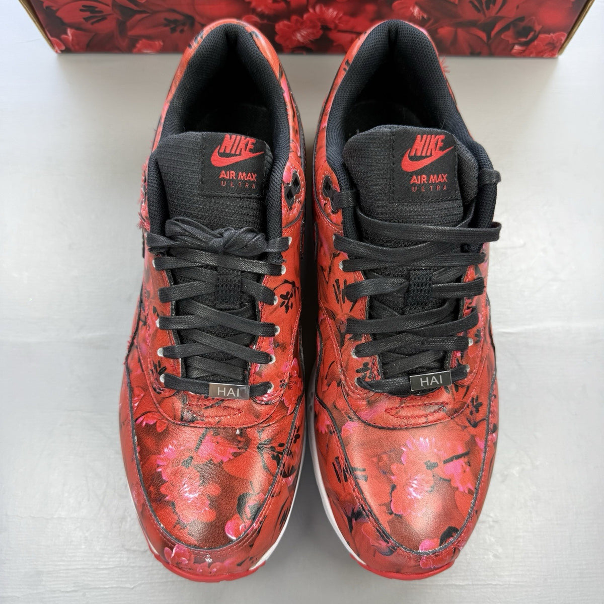 Nike Air Max 1 red trainers with white accents and classic logo detail.