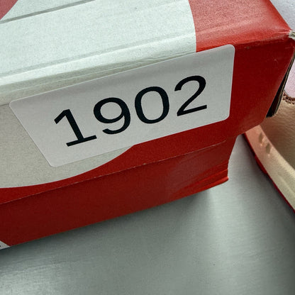 Nike Air Max 1 trainers white with university red accents and cream detailing.