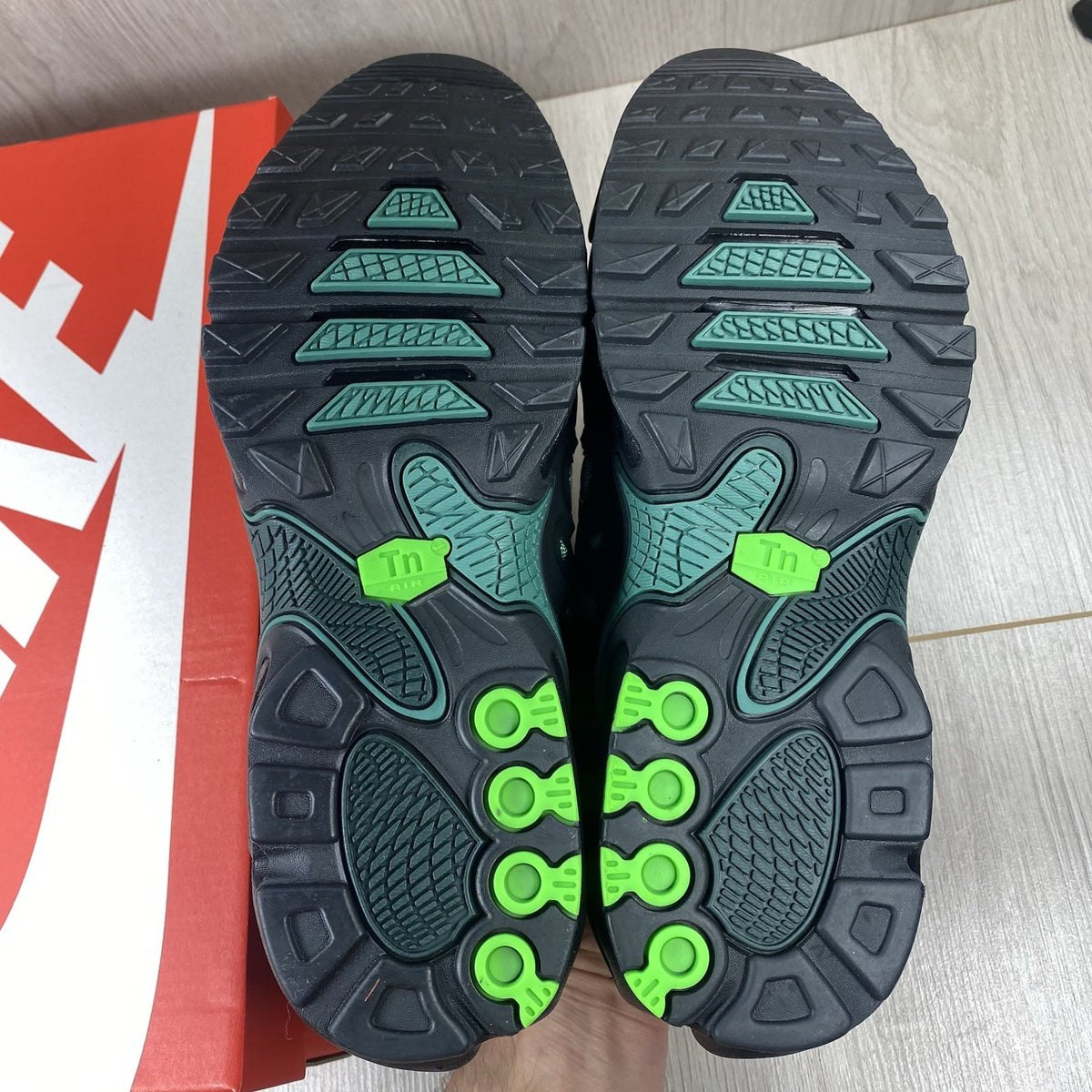 Nike Air Max Plus trainers black with volt green accents and signature swoosh logo.