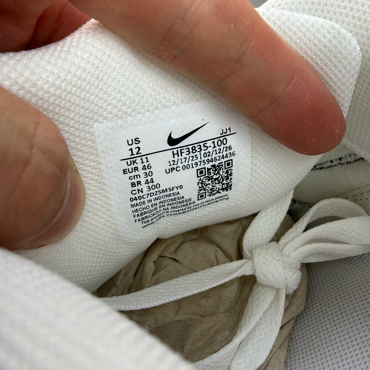 Nike Air Max 90 white trainers with black outlined swoosh logo and mesh material.